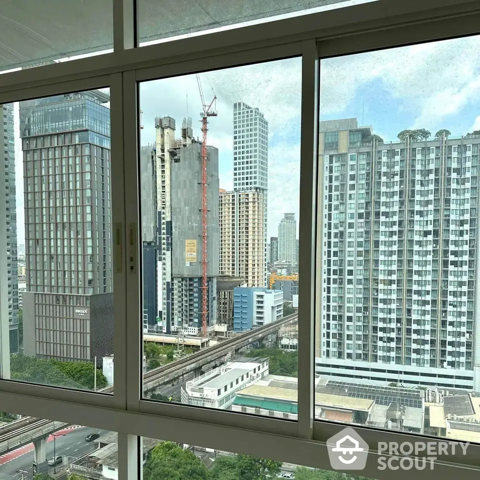 Stunning cityscape view from high-rise apartment window showcasing urban skyline.