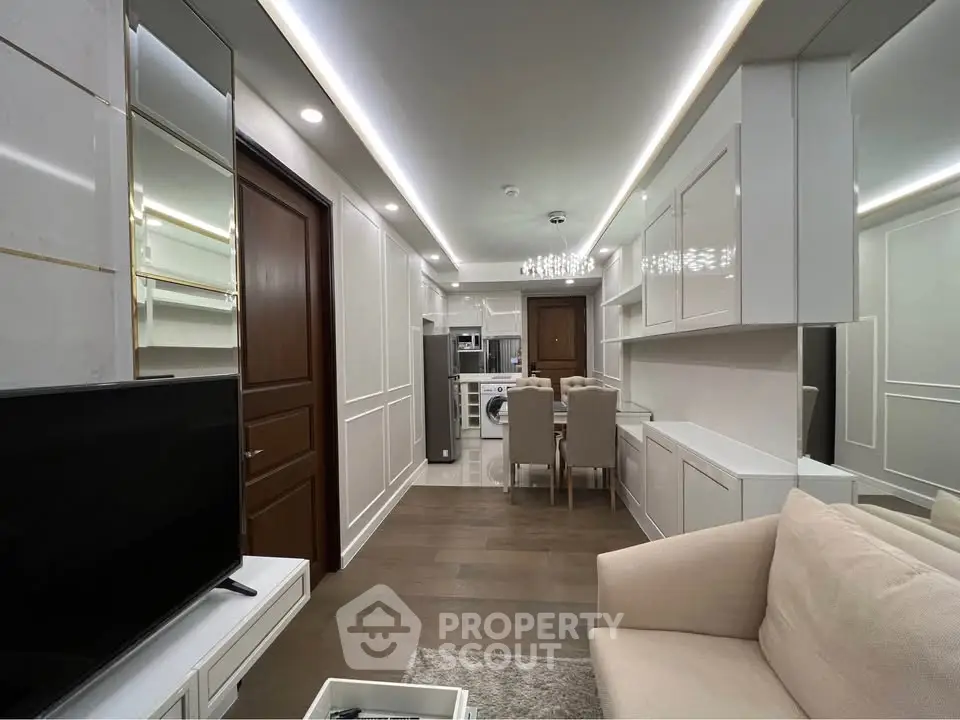 Modern living room with sleek design, featuring a cozy sofa, flat-screen TV, and elegant dining area.