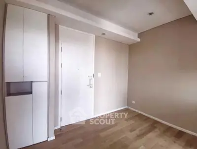 Minimalist empty room with wooden flooring and modern cabinetry