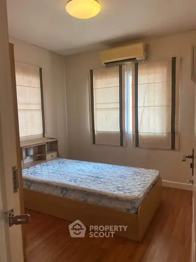 Cozy bedroom with wooden flooring and natural light