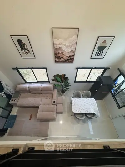 Modern living room with stylish decor and dining area, featuring elegant furniture and large windows.