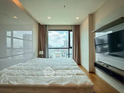 Spacious bedroom with city view, modern furnishings, and large window for natural light.