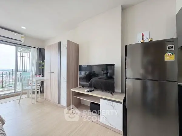 Modern living room with balcony view, featuring sleek TV unit and stainless steel fridge.