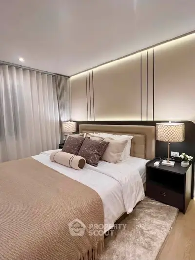Luxurious modern bedroom with elegant lighting and plush bedding in a stylish apartment.