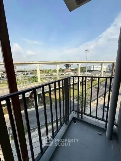 Modern balcony with city view and nearby highway, perfect for urban living.