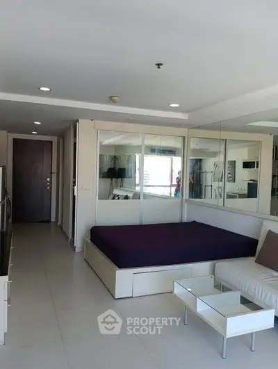 Modern studio apartment with mirrored walls and sleek furniture design