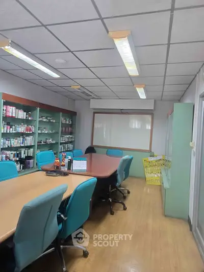 Spacious office meeting room with modern furnishings and ample shelving space.