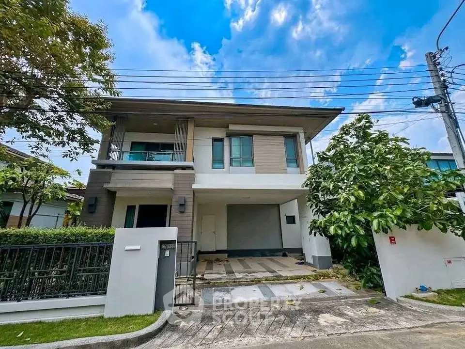 Modern two-story house with spacious driveway and lush greenery in a serene neighborhood.