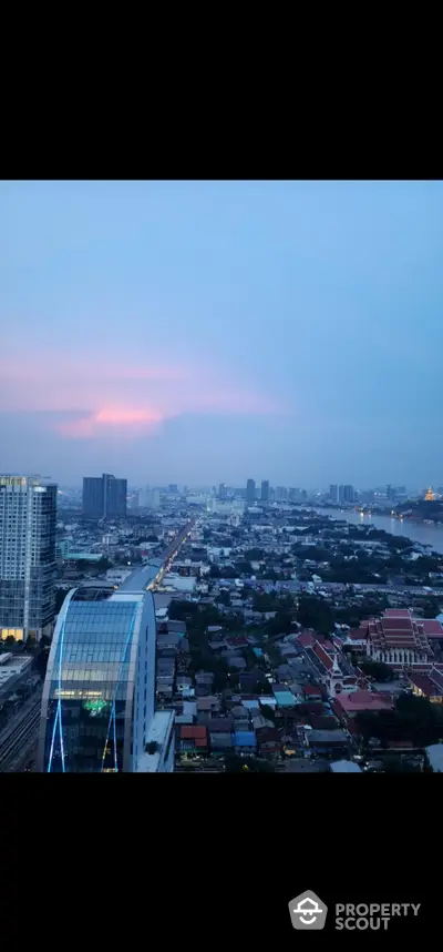 Stunning cityscape view from high-rise building at sunset, showcasing urban skyline and vibrant horizon.