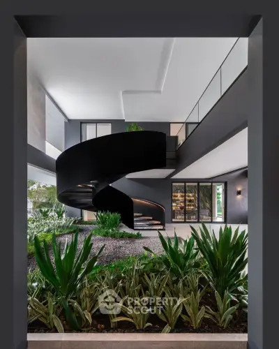 Stunning modern building entrance with spiral staircase and lush greenery