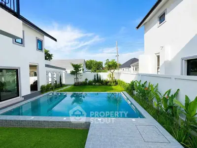 Luxurious modern home with a stunning private pool and lush garden, perfect for relaxation and entertainment.