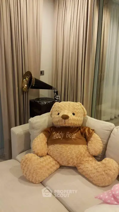 Cozy living room with plush teddy bear and vintage gramophone on beige sofa.
