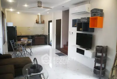 Modern living room with open kitchen, sleek furniture, and stylish decor in a contemporary apartment.