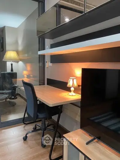 Modern study area with sleek desk, chair, and ambient lighting in a stylish apartment.