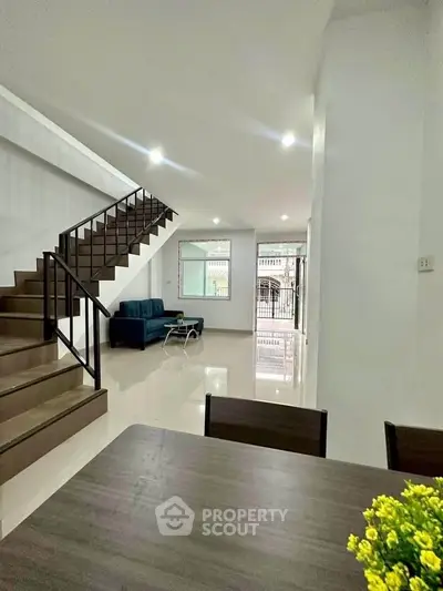 Spacious modern living room with staircase and natural light