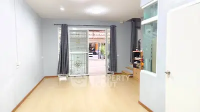 Spacious living room with wooden flooring and large windows