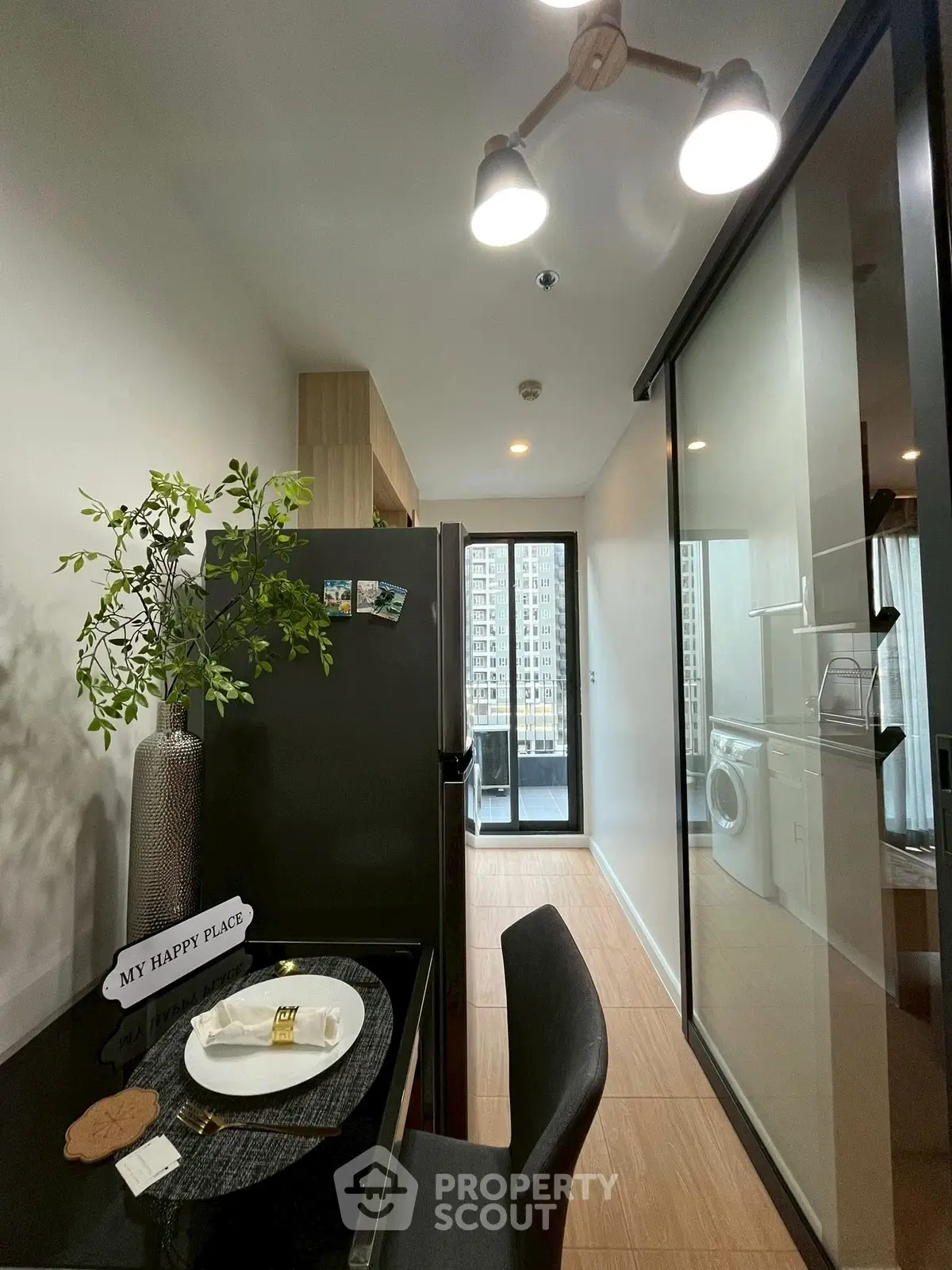 Modern kitchen with sleek appliances and a view of the city from the balcony.