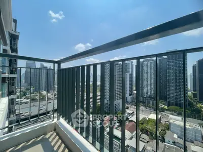 Stunning cityscape view from a high-rise balcony with modern railings and clear blue sky.