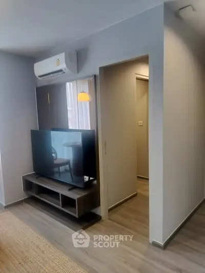 Modern living room with sleek TV setup and air conditioning, perfect for comfortable living.