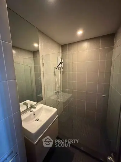 Modern bathroom with sleek shower and stylish sink in contemporary apartment.