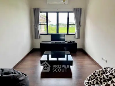Modern living room with sleek furniture and large window view.