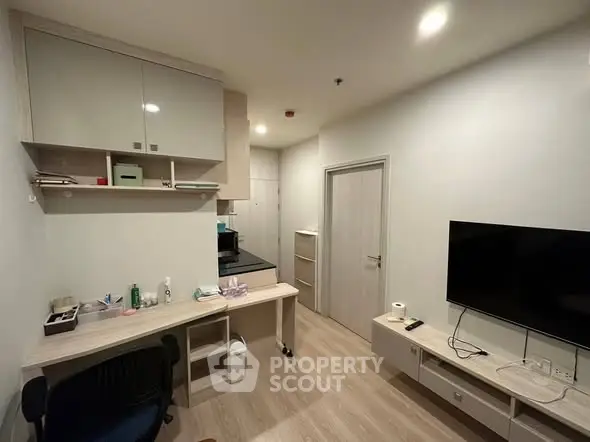 Modern compact living room with sleek design and mounted TV, perfect for urban living.
