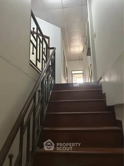 Charming staircase with wooden steps and elegant railing in a cozy home interior.