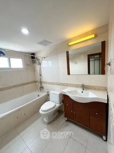 Spacious bathroom with modern fixtures and bathtub in a well-lit setting.