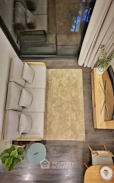 Modern living room with cozy sofa, stylish decor, and large window view.
