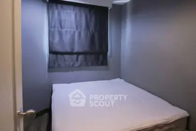 Cozy minimalist bedroom with dark curtains and soft lighting, perfect for restful nights.