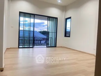 Spacious empty room with large windows and balcony view, perfect for customization.