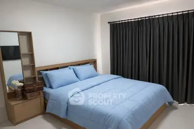 Cozy bedroom with modern furnishings and elegant curtains, perfect for relaxation and comfort.