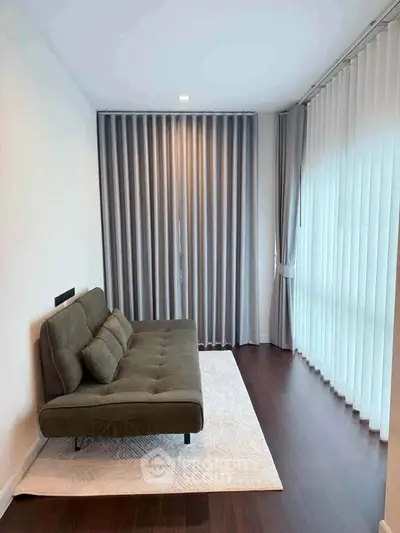 Modern living room with stylish sofa and floor-to-ceiling curtains in a cozy apartment.