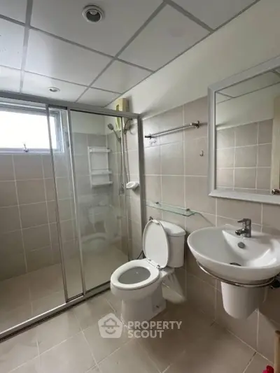 Modern bathroom with glass shower and sleek fixtures in real estate property
