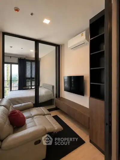 Modern living room with sleek furniture and a view into a cozy bedroom, perfect for urban living.