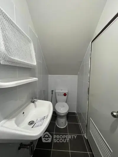Compact bathroom with modern fixtures and sleek tile flooring, ideal for efficient space utilization.