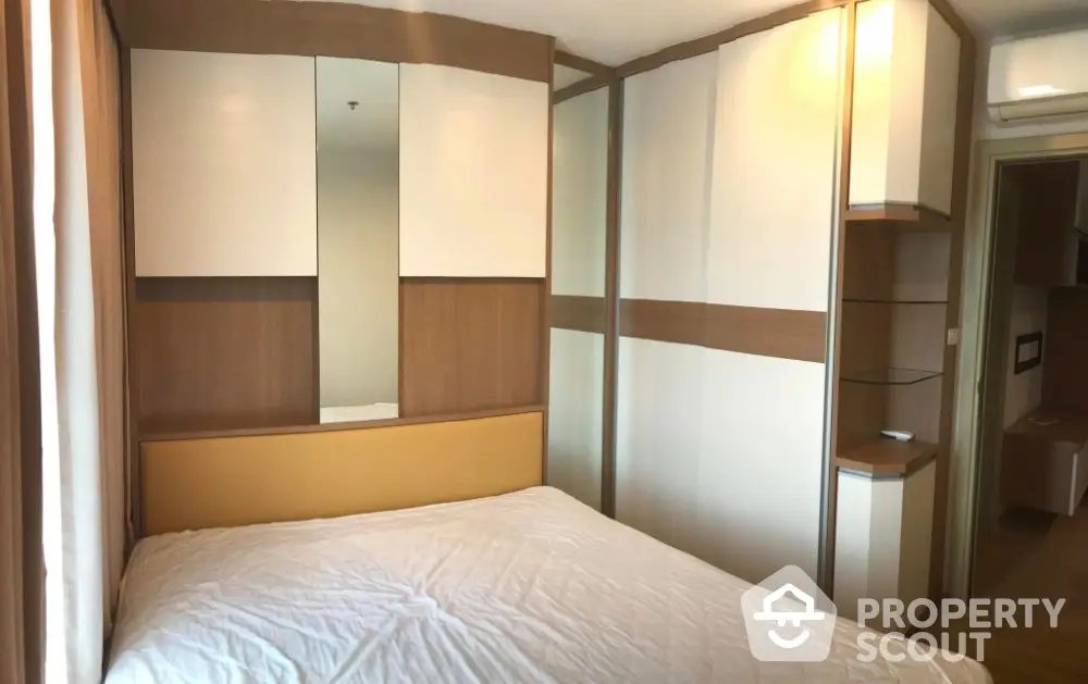 Modern bedroom with stylish built-in wardrobe and cozy bed in a contemporary apartment.