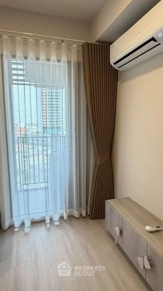 Modern living room with air conditioning and balcony view, featuring elegant curtains and wooden flooring.