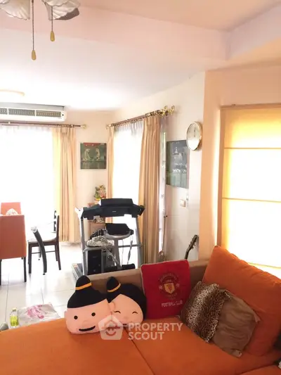 Cozy living room with bright decor and treadmill, perfect for relaxation and fitness.