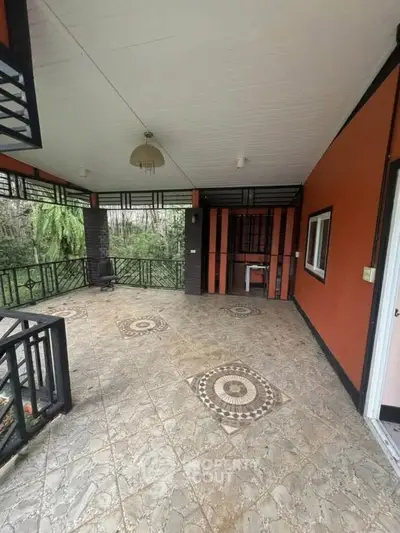 Spacious covered balcony with decorative tiles and forest view, perfect for relaxation.