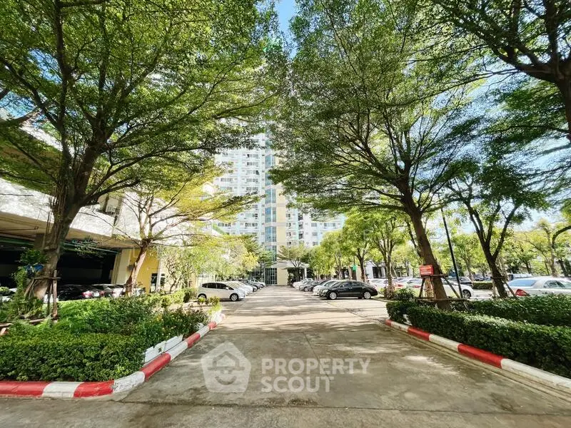 Lush garden entrance with ample parking at modern residential building