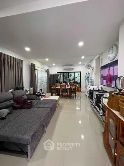 Spacious living room with modern decor and ample natural light, perfect for family gatherings.