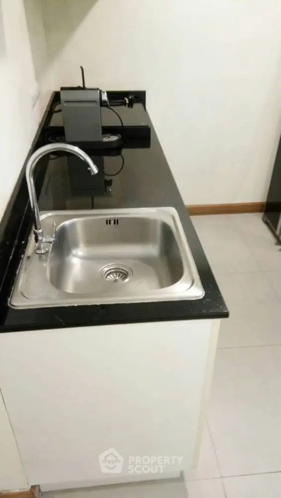 Modern kitchen with sleek black countertop and stainless steel sink