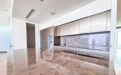 Luxurious modern kitchen with marble countertops and sleek cabinetry in high-end apartment.