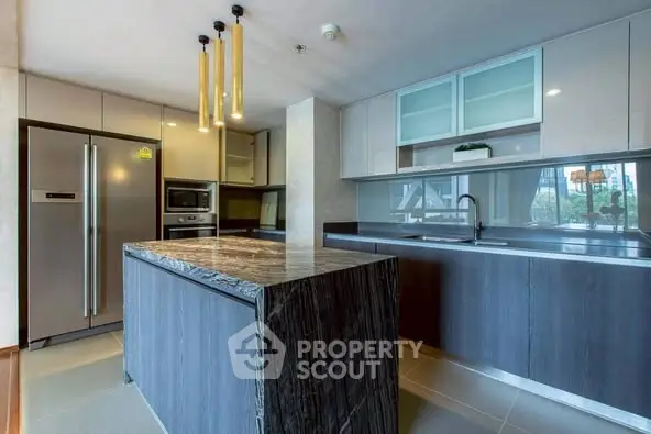 Modern kitchen with sleek design, featuring a large island and stainless steel appliances.