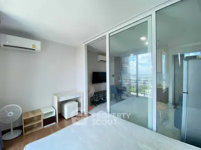 Modern bedroom with balcony view and air conditioning in a stylish apartment.