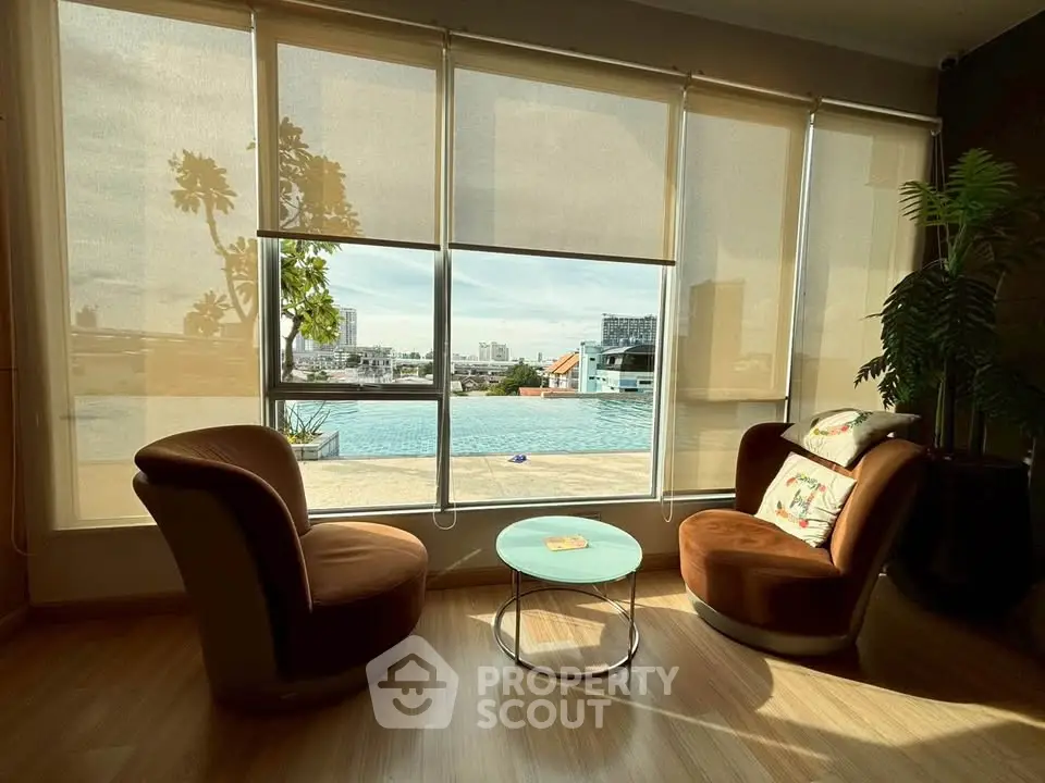 Luxurious living room with pool view and stylish seating, perfect for relaxation and entertainment.
