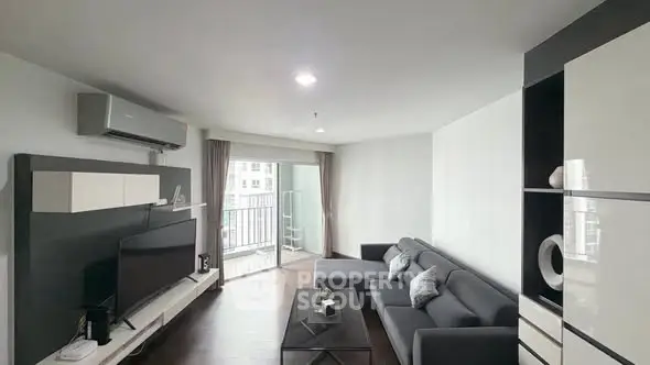 Modern living room with sleek furniture and balcony access in a stylish apartment.