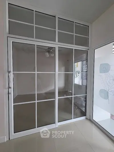 Modern interior with glass sliding doors and tiled flooring, perfect for a bright and airy living space.