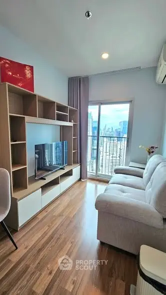 Modern living room with city view, featuring cozy sofa and entertainment unit.